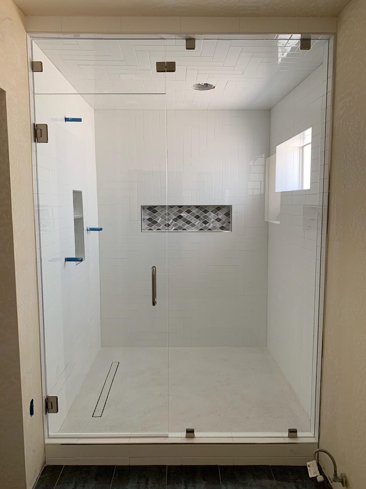 Full height frameless steam shower with transom panel and linear drain