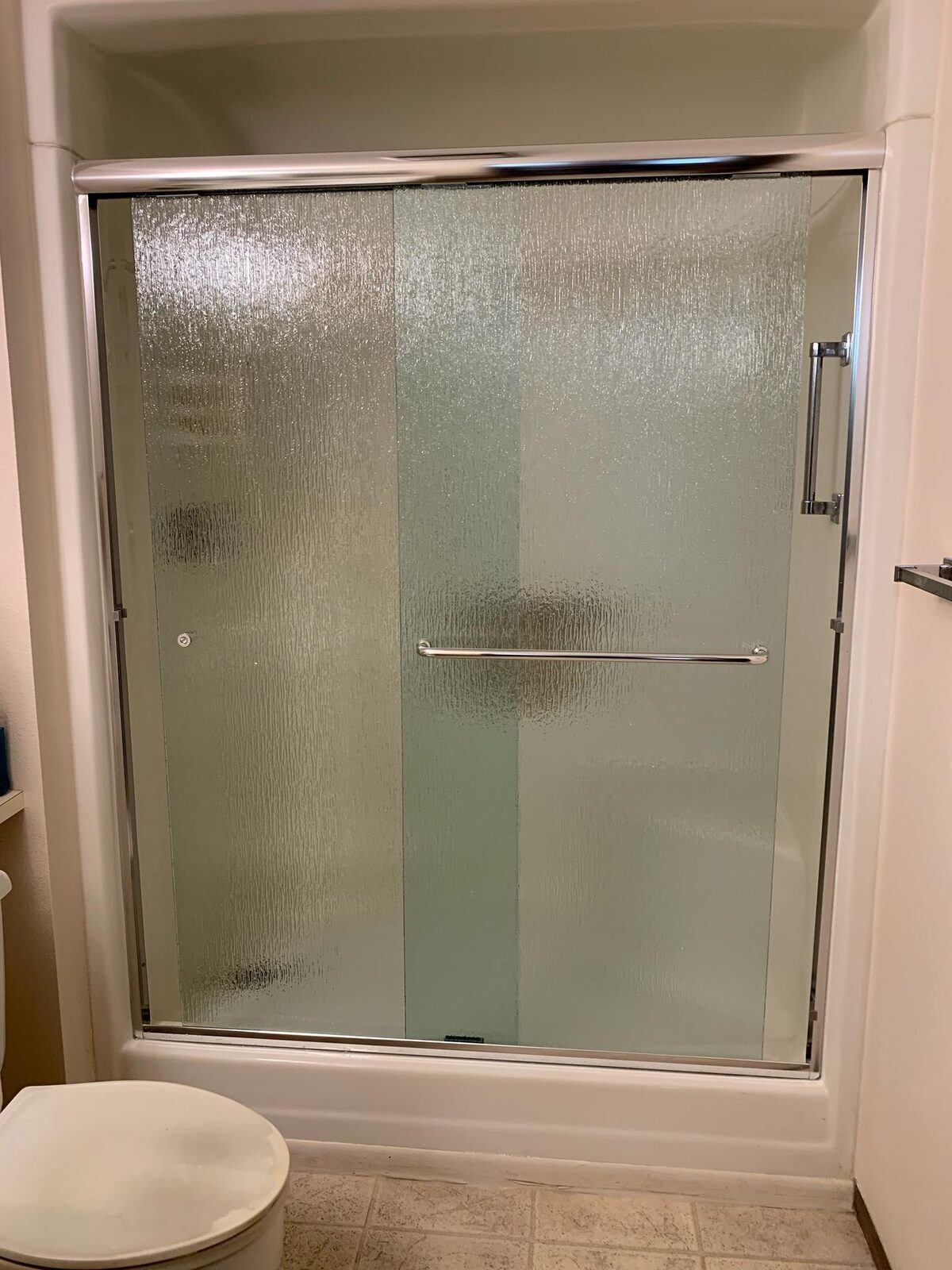 Semi frameless rain glass bypass door over a tub with brushed nickel rails