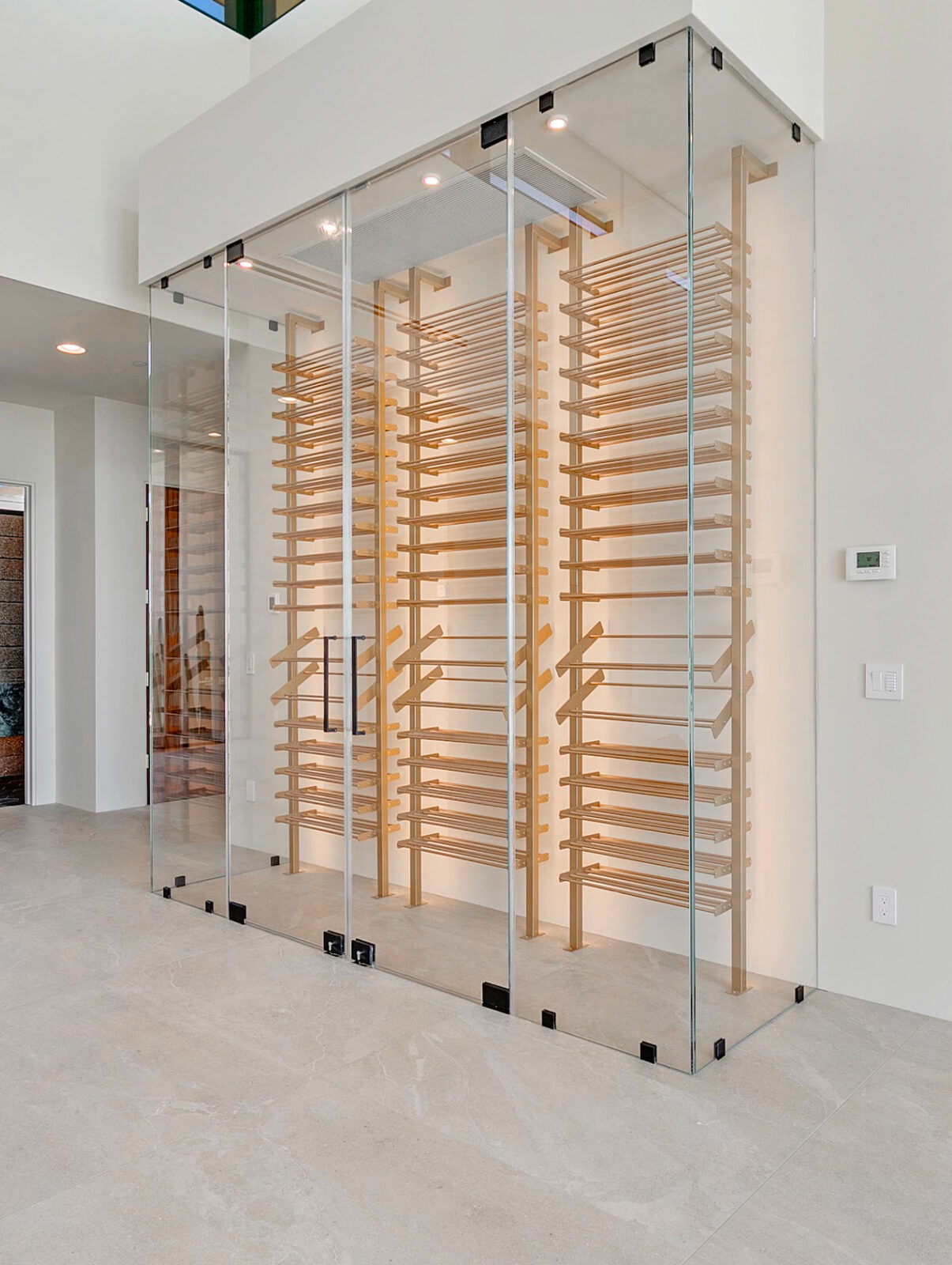 Floor to ceiling frameless glass wine room with wood racking