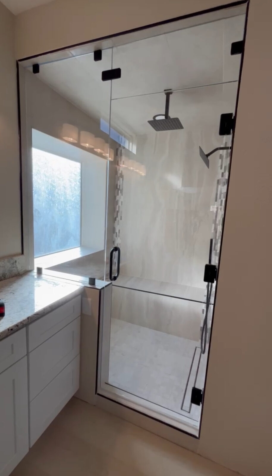 Steam shower enclosure with black framed door and window wall