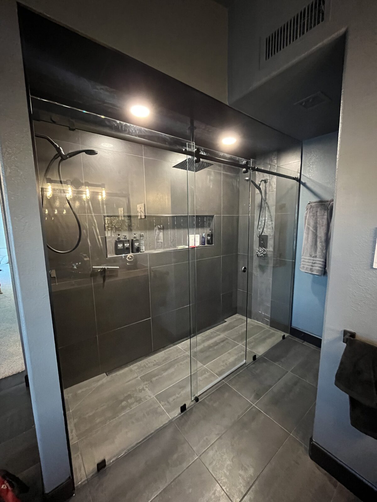 Matte black barn style slider on a white tiled tub and shower combination