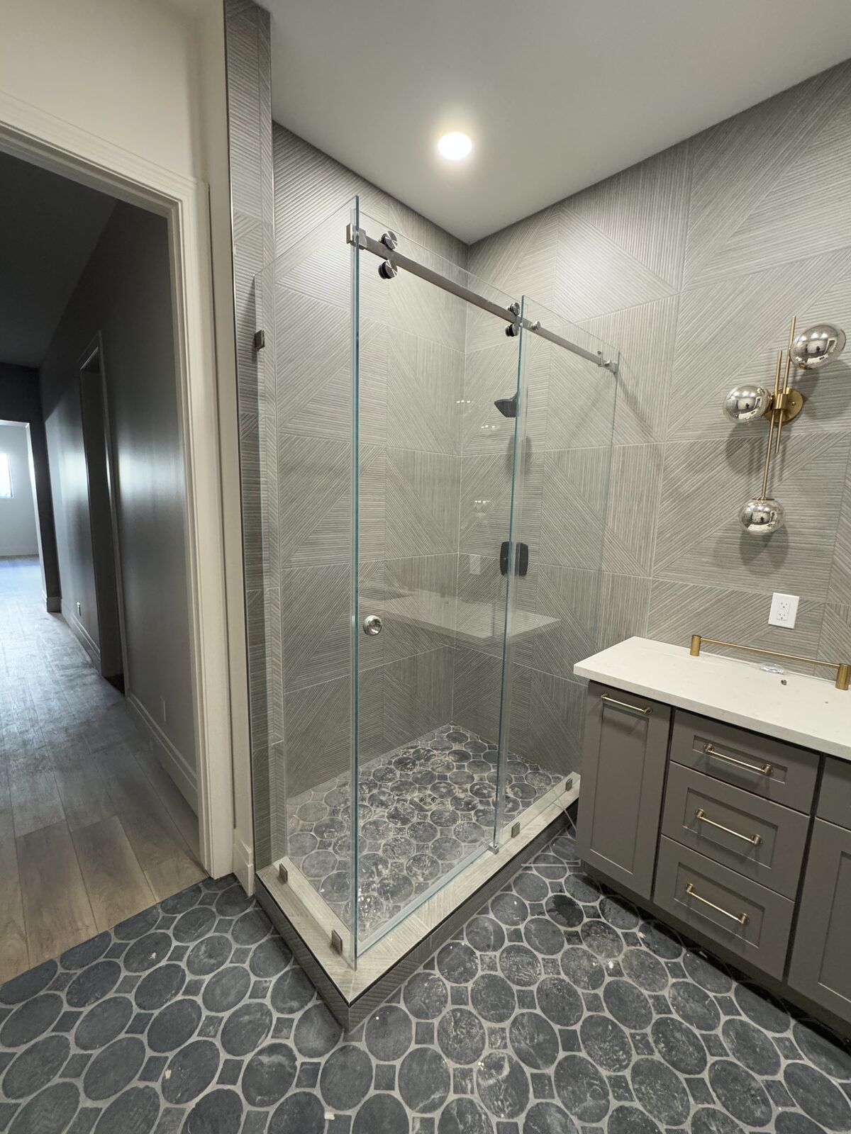 Black barn style sliding shower door with patterned cement floor tile